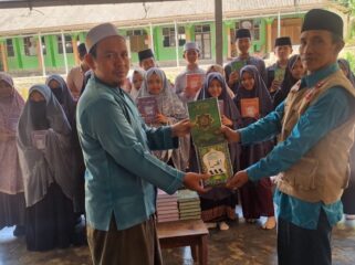 Pembina Tegar sekaligus Anggota Taga Kota Mataram, Taufik Al Hidayat menyerahkan bantuan Al-Qur'an dan Iqro' kepada guru ngaji di TPQ Nurul Qur'an NW Dusun Pelah, Desa Rarang, Kecamatan Terara, Kabupaten Lombok Timur. (Foto: Dok Tegar Kota Mataram) 