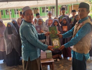 Pembina Tegar sekaligus Anggota Taga Kota Mataram, Taufik Al Hidayat menyerahkan bantuan Al-Qur'an dan Iqro' kepada guru ngaji di TPQ Nurul Qur'an NW Dusun Pelah, Desa Rarang, Kecamatan Terara, Kabupaten Lombok Timur. (Foto: Dok Tegar Kota Mataram) 