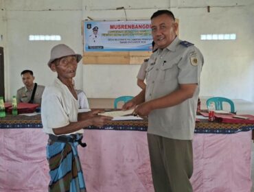 I Nyoman Sadiarsa, S.SiT, Ketua Tim PTSL Kantor Pertanahan Kabupaten Lombok Tengah menyerahkan sertipikat kepada masyarakat di Desa Bilebante. (Foto : Dok/Ist)